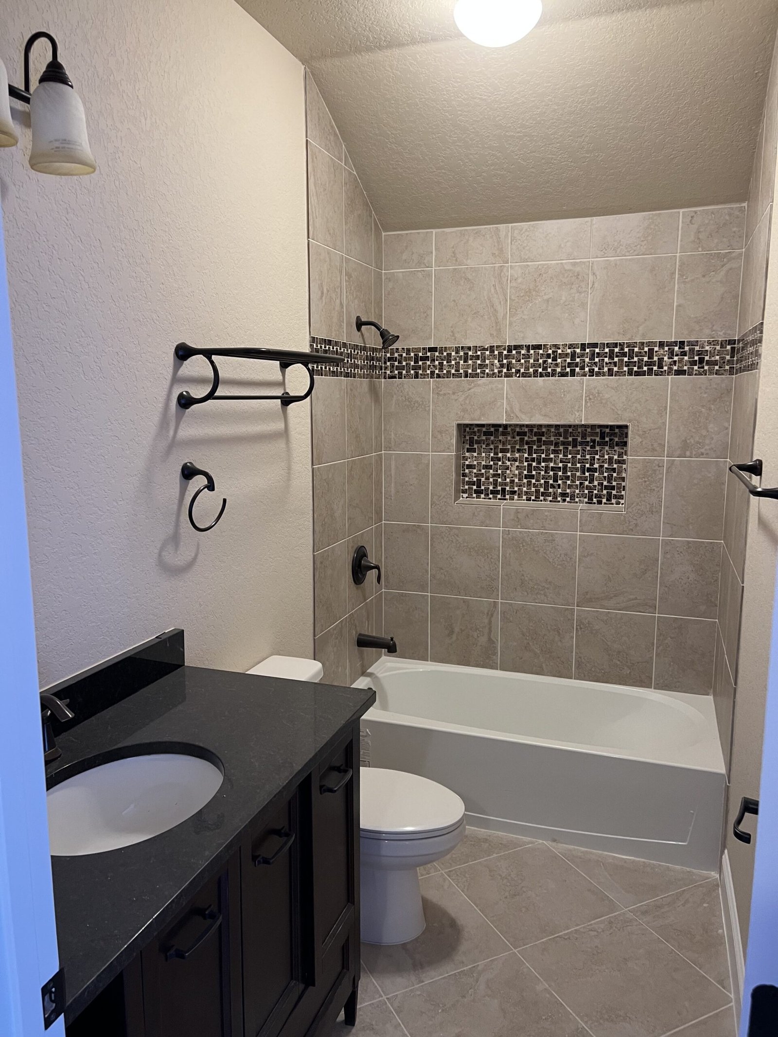 Fully renovated luxury bathroom featuring custom tile and fixtures by Bath By Design SA in San Antonio, Texas.
